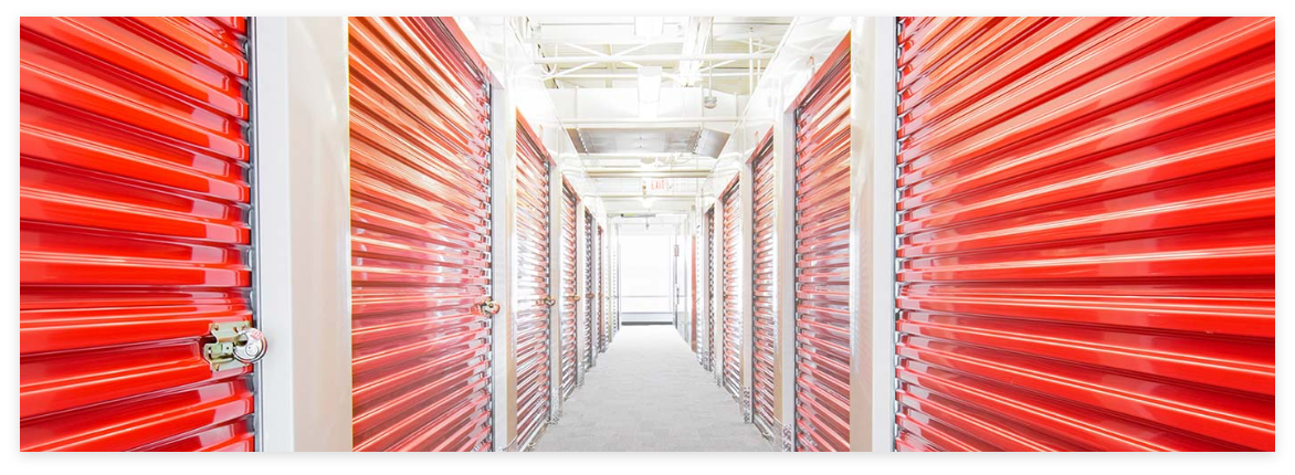 Self storage building with orange rolling doors.