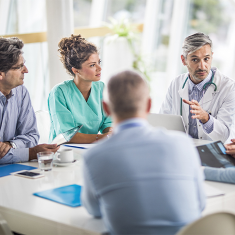 Group of doctors seated around table.